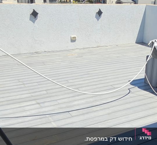 מרפסת עץ עם נוף לבתים וגבעות ברקע